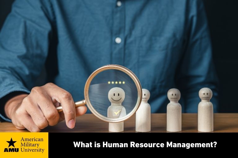 what-is-human-resource-management human resource professional holding magnifying glass in front of wooden figure