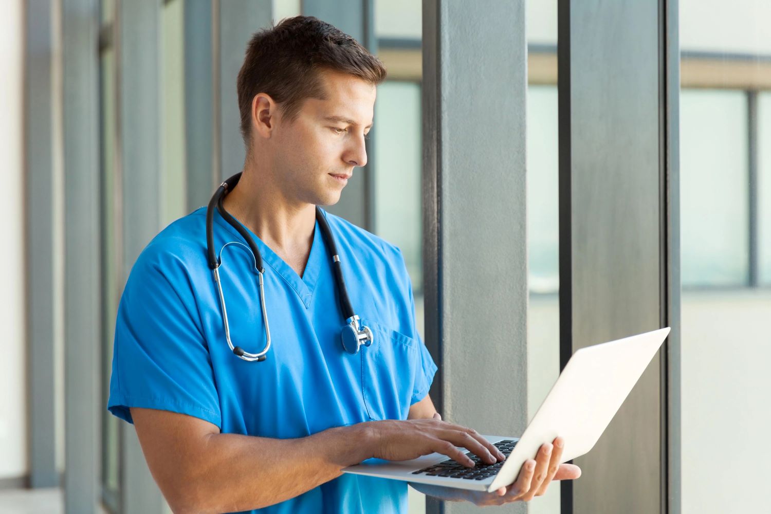 male nurse looking at laptop